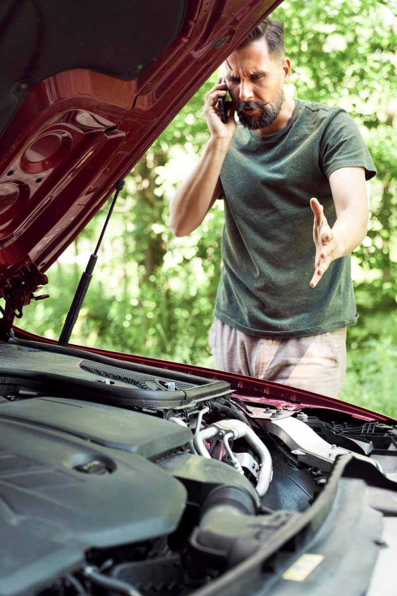 Junger Mann prüft Getriebeschaden bei Schrottauto Ankauf Lohmar